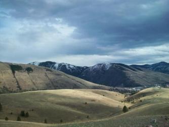 Hills looking towards the mountains ~  North Hills, Missoula, MT, March 29, 2010. Note the L of Mt. Jumbo and the M of Mt. Sentinel. A sunny windy day, everything greening... barely. 